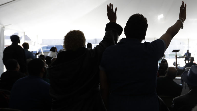 Worshippers pray during a service in a tent at Mount Bethel Missionary Baptist Church on March 8, 2020, in Nashville, Tennessee. The congregation held its Sunday service in a tent in the parking lot near the church facilities, which were heavily damaged by a tornado March 3. (AP Photo/Mark Humphrey)