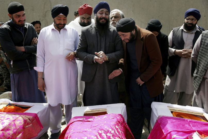 Afghan Sikh men mourn their loved ones during a funeral March 26, 2020, for those who were killed the day before when a lone Islamic State gunman rampaged through a Sikh gurdwara in Kabul, Afghanistan. An explosive device then disrupted Thursday's funeral services for the 25 members of Afghanistan's Sikh minority community who were killed. (AP Photo/Tamana Sarwary)