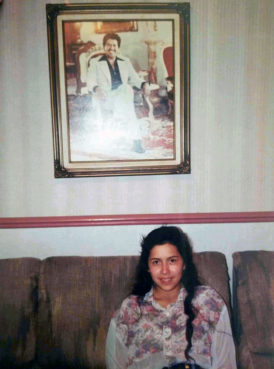 Raquel Guerra at a pastor’s home in Santa Maria, California, on the day of her baptism in 1993. A photograph of Samuel Joaquín Flores, father of Naasón Joaquín García, hangs above her. Photo courtesy of Raquel Guerra