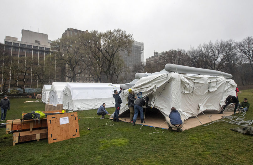A Samaritan's Purse crew works on building an emergency field hospital equipped with a respiratory unit in New York's Central Park, across from the Mount Sinai Hospital, on March 29, 2020. (AP Photo/Mary Altaffer)
