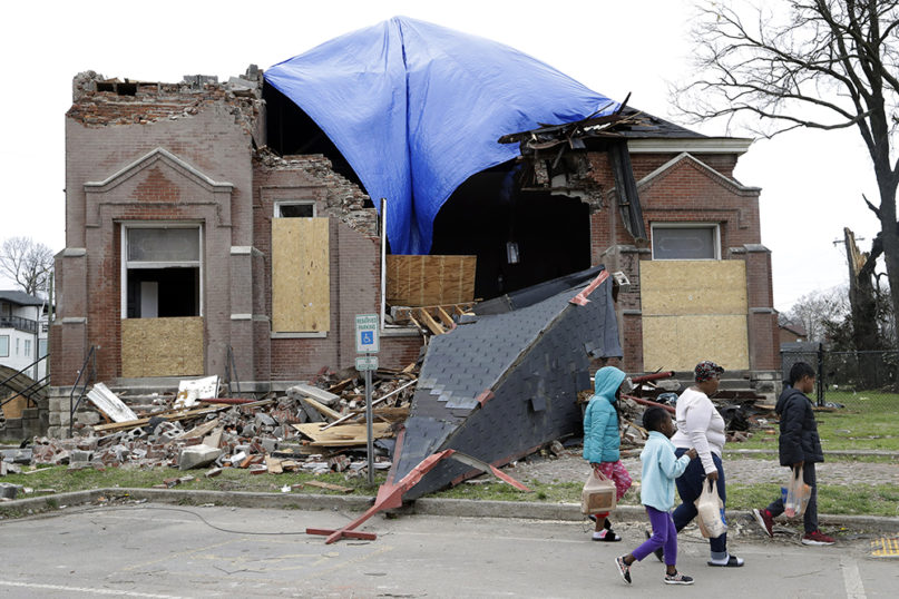 People pass the damaged Hopewell Missionary Baptist Church, Wednesday, March 4, 2020, in Nashville, Tenn. (AP Photo/Mark Humphrey)