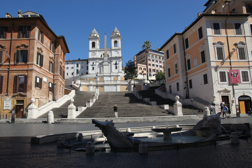 A single individual, center, takes a photo at Rome’s famous Spanish Steps on March 12, 2020, as a camera crew works on the right. Photo by Federico Manzoni