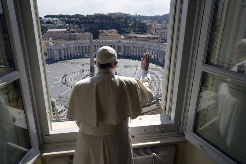 Pope Francis delivers his blessing over an empty St. Peter’s Square from inside the Apostolic library at the Vatican on March 15, 2020. (Vatican News via AP)