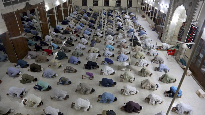 People attend evening prayers with maintaining distance to help avoid the spread of coronavirus, at a mosque in Karachi, Pakistan, Sunday, April 19, 2020. Pakistan Prime Minister Imran Khan’s government bowed to demands by religious leaders and agreed to keep mosques open during the Islamic fasting month of Ramadan. (AP Photo/Fareed Khan)