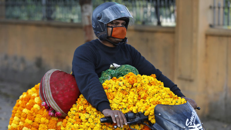 A man transports Marigold flower garlands on a motorbike during the  Ashtami, eighth day of the nine-day Navratri festival  in Prayagraj, India,, Wednesday, April 1, 2020. Hindus celebrate Navaratri, or the festival of nine nights, with three days each devoted to the worship of Durga, the goddess of valor, Lakshmi, the goddess of wealth, and Saraswati, the goddess of knowledge. (AP Photo/Rajesh Kumar Singh)
