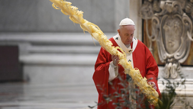 Pope Francis holds a palm branch as he celebrates Palm Sunday Mass behind closed doors in St. Peter's Basilica, at the Vatican, on April 5, 2020, during the lockdown aimed at curbing the spread of the COVID-19 infection, caused by the novel coronavirus. (AP Photo/pool/Alberto Pizzoli)