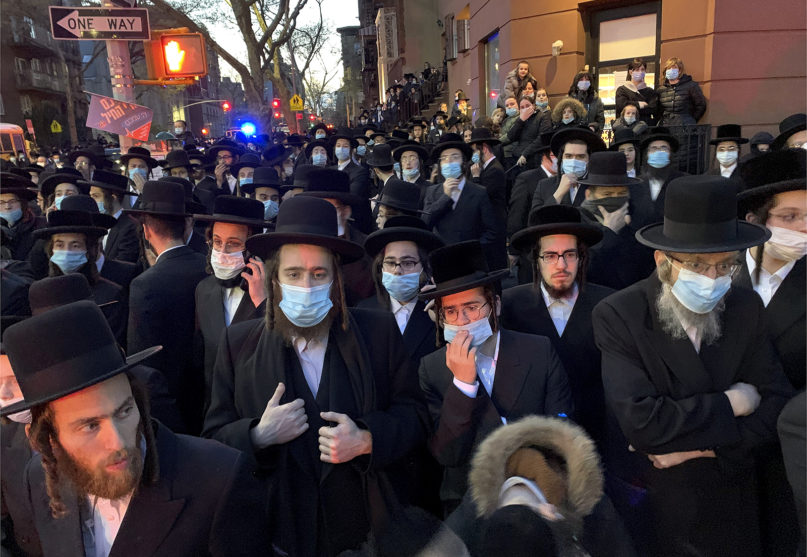 Hundreds of mourners gather in the Brooklyn borough of New York, Tuesday, April 28, 2020, to observe a funeral for Rabbi Chaim Mertz, a Hasidic Orthodox leader whose death was reportedly tied to the coronavirus. The stress of the coronavirus' toll on New York City's Orthodox Jews was brought to the fore after Mayor Bill de Blasio chastised 