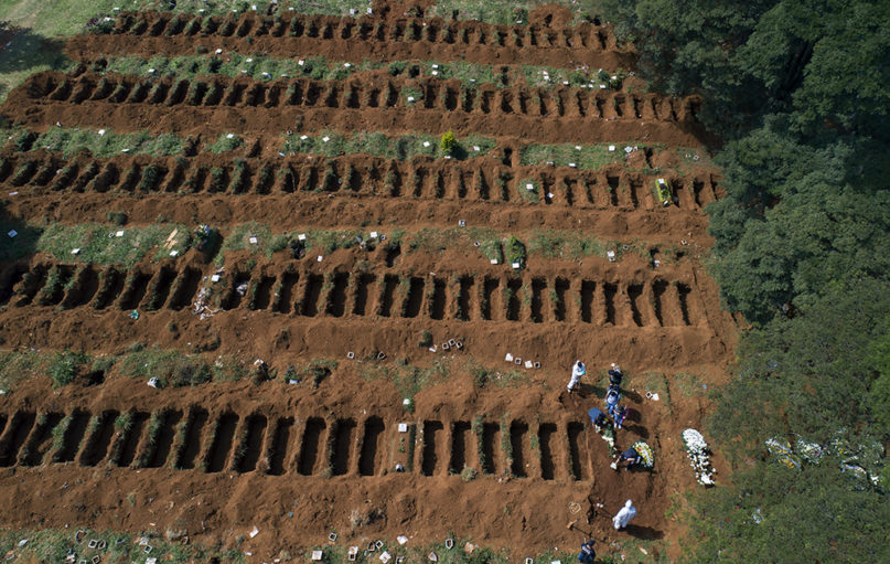 Cemetery workers in protective clothing bury a person at the Vila Formosa cemetery in Sao Paulo, Brazil, on April 1, 2020. Vila Formosa cemetery, the largest in Latin America, has had a 30% increase in the number of burials amid the spread of the new coronavirus, according to the cemetery's administration. (AP Photo/Andre Penner)