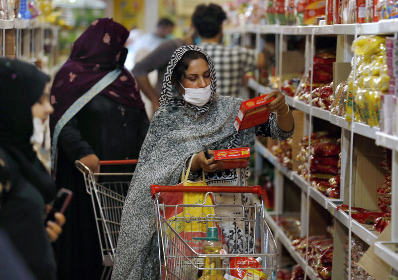 A woman selects food options in a government-run supermarket, which provides special discount prices for the upcoming Muslim fasting month of Ramadan, in Islamabad  on April 22, 2020. Ramadan begins with the new moon later this week as Muslims all around the world are trying to work out how to maintain the many cherished rituals of Islam's holiest month amid the coronavirus pandemic. (AP Photo/Anjum Naveed)