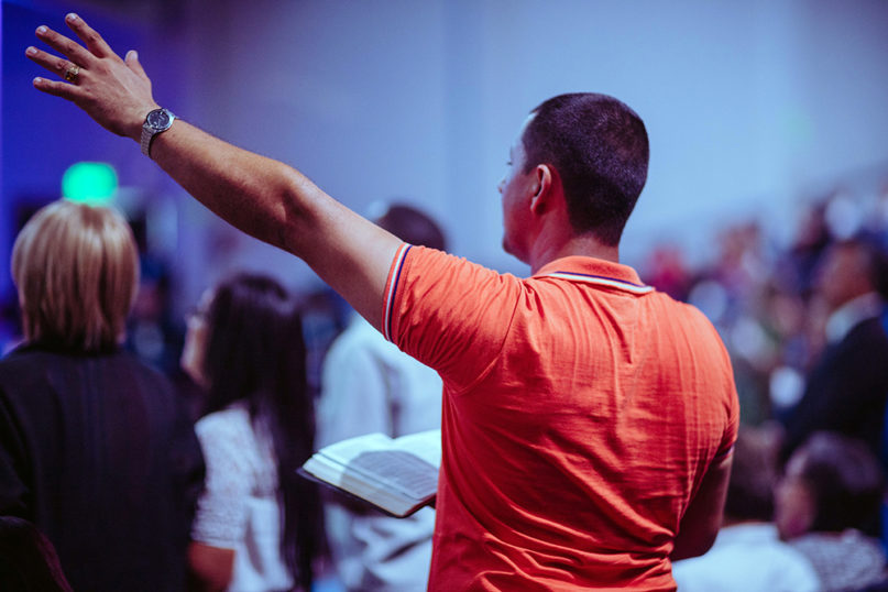 A man raises his hand during worship. Photo by Luis Quintero/Pexels/Creative Commons