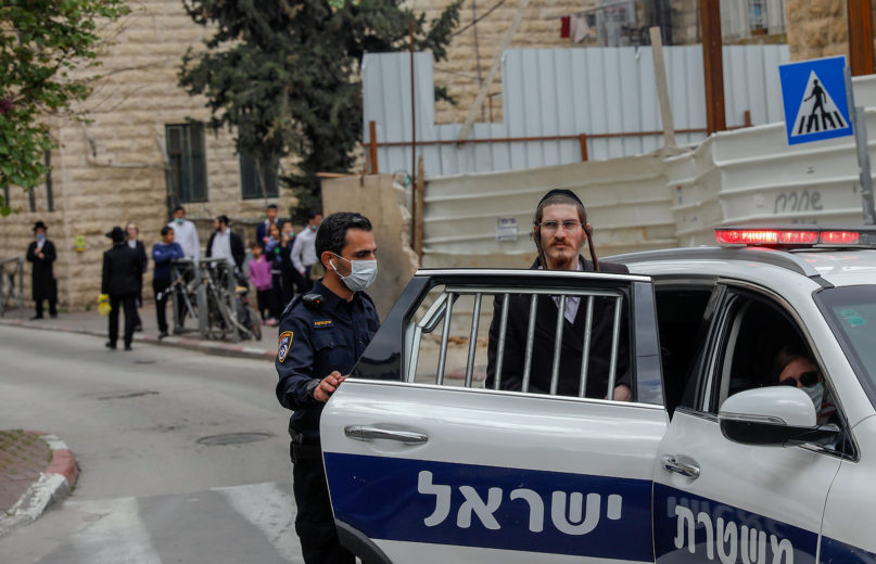 An Ultra-Orthodox Jewish man is arrested by Israeli security forces as they shut down a synagogue in the Mea Shearim Ultra-Orthodox neighbourhood in Jerusalem, on April 17, 2020, amid efforts to curb the spread of the COVID-19 coronavirus pandemic. (Photo by AHMAD GHARABLI/AFP via Getty Images)