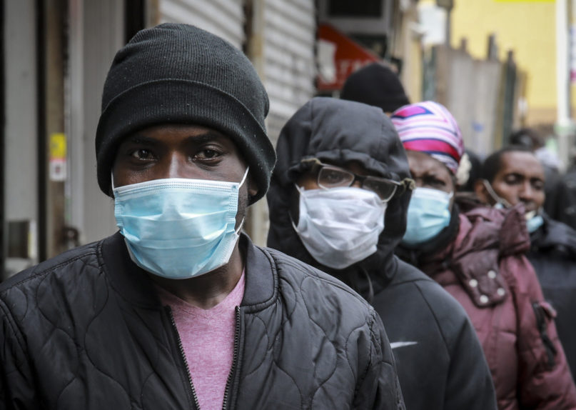 People wait for a distribution of masks and food from the Rev. Al Sharpton on April 18, 2020, in the Harlem neighborhood of New York after a new state mandate was issued requiring residents to wear face coverings in public due to the coronavirus. “Inner-city residents must follow this mandate to ensure public health and safety,” said Sharpton. The latest Associated Press analysis of available data shows that nearly one-third of those who have died from the coronavirus were African American, even though blacks are only about 14% of the population. (AP Photo/Bebeto Matthews)