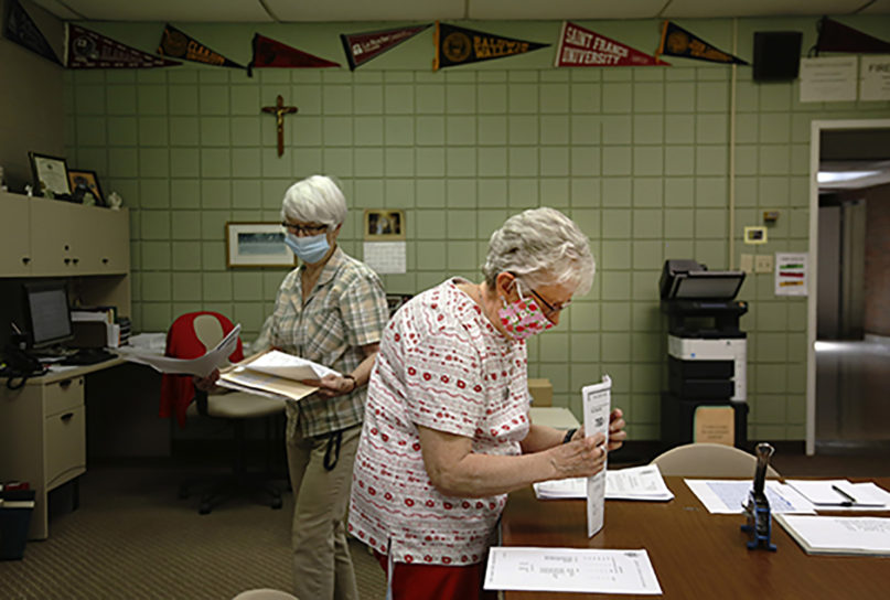 Guidance secretary Marge Berckmiller, left, and Sister Bridget Reilly, director of guidance, prepare student transcripts to send to other schools after the closure of Quigley Catholic High School in Baden, Pa., Monday, June 8, 2020. The staff learned of the closure May 29 via videoconference. (AP Photo/ Jessie Wardarski)