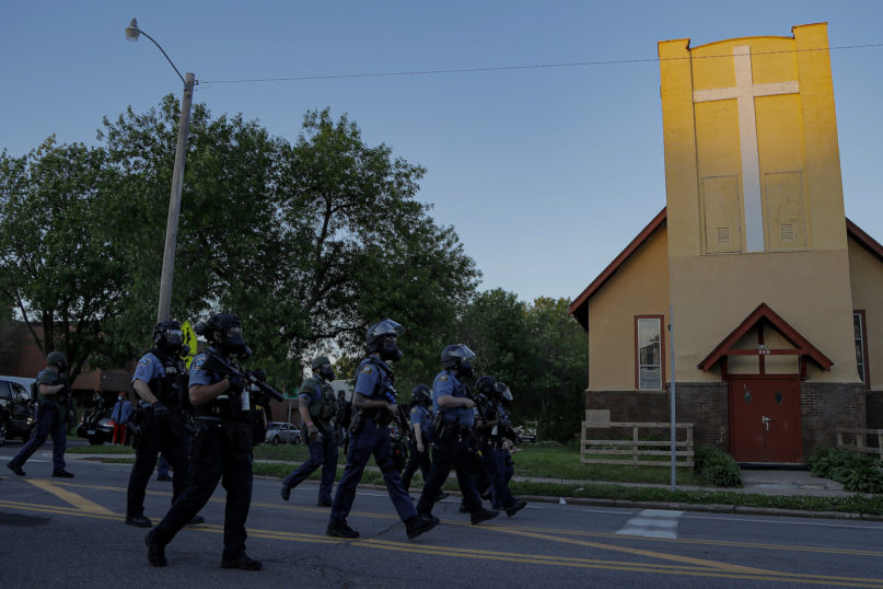 St. Paul Police officers move in on a crowd, Thursday, May 28, 2020, in St. Paul, Minn. Violent protests over the death of George Floyd, the black man in police custody broke out in Minneapolis for a second straight night Wednesday, with protesters in a standoff with officers outside a police precinct and looting of nearby stores. (AP Photo/Julio Cortez)