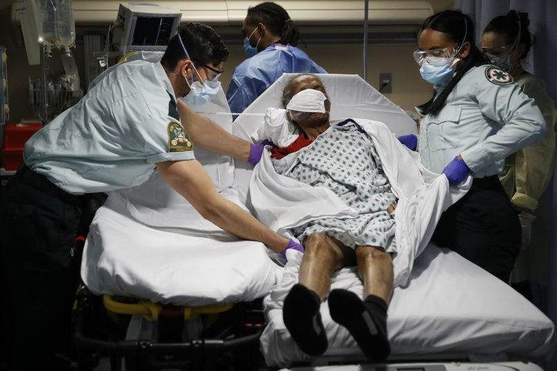 In this April 20, 2020, file photo, emergency medical technicians transport a patient from a nursing home to an emergency room bed at St. Joseph's Hospital in Yonkers, New York. A grim blame game with partisan overtones is breaking out over COVID-19 deaths among nursing home residents, a tiny slice of the population that represents a shockingly high proportion of Americans who have perished in the pandemic. (AP Photo/John Minchillo, File)