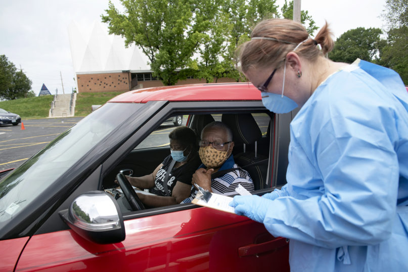 Care STL nurse Amy Heidotten, right, takes information from Eleanor James, left, and her husband, Maxwell James, at a free coronavirus testing site June 5, 2020, at Christ the King United Church of Christ in Florissant, Missouri. The church, which has been giving away masks and hand sanitizer to members of the community, collaborated with Care STL Health and Faith for the Sake of All Others to offer free COVID-19 tests. RNS photo by Nick Schnelle