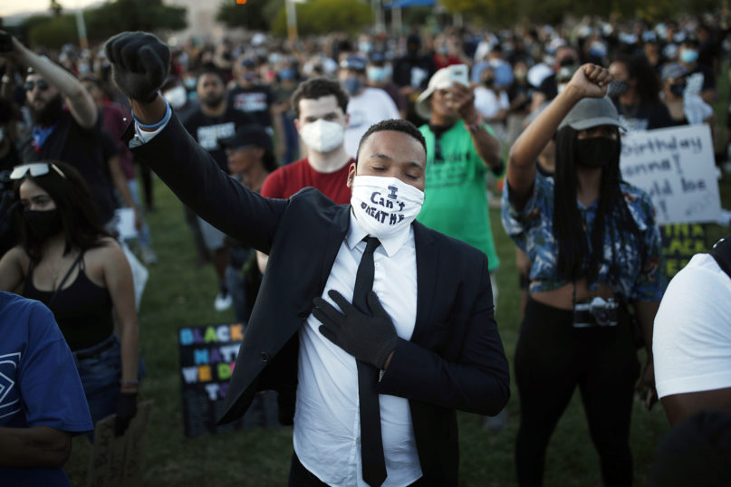 People raise their fists during a rally, Friday, June 5, 2020, in Las Vegas, against police brutality sparked by the death of George Floyd, a black man who died after being restrained by Minneapolis police officers on May 25. (AP Photo/John Locher)