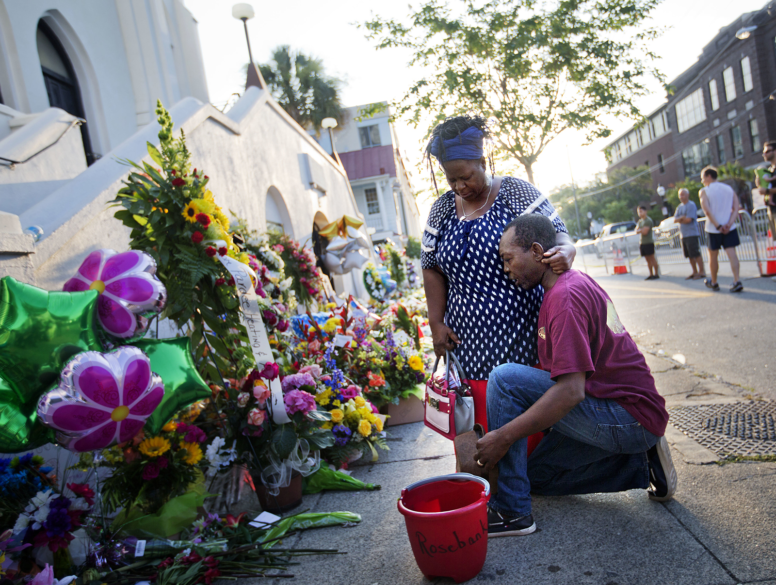 In this June 20, 2015, file photo, Allen Sanders, right, kneels next to his wife, Georgette, both of McClellanville, South Carolina, as they pray at a sidewalk memorial in memory of the shooting victims in front of Mother Emanuel AME Church in Charleston, South Carolina. (AP Photo/David Goldman, File)