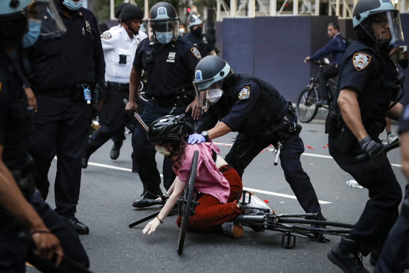 A protester is arrested by New York Police Department officers for violating curfew beside the iconic Plaza Hotel on 59th Street on June 3, 2020, in the Manhattan borough of New York. Protests continued over the death of George Floyd, who died after being restrained by Minneapolis police officers on Memorial Day. (AP Photo/John Minchillo)