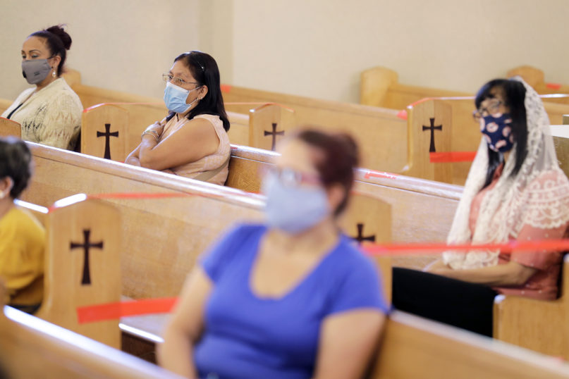 People attend Mass, in pews marked with tape for social distancing, at St. Agnes Church in Paterson, New Jersey, on June 14, 2020. (AP Photo/Seth Wenig)