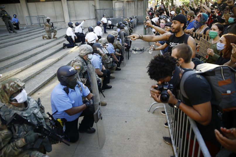 Philadelphia police and Pennsylvania National Guard take a knee at the suggestion of Philadelphia Police Deputy Commissioner Melvin Singleton, unseen, outside Philadelphia police headquarters on June 1, 2020, during a rally calling for justice over the death of George Floyd. (AP Photo/Matt Rourke)