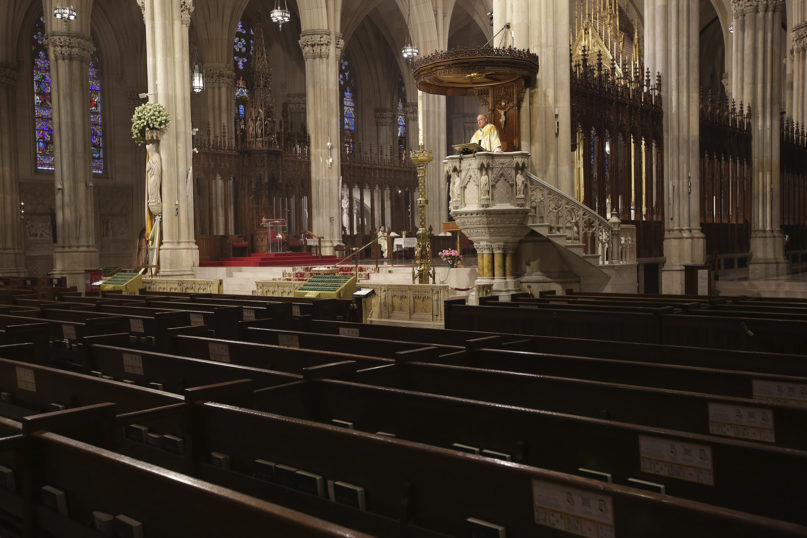 Archbishop Timothy Dolan delivers his homily over empty pews as he leads an Easter Mass at St. Patrick's Cathedral in New York, Sunday, April 12, 2020. Due to coronavirus concerns, no congregants were allowed to attend the Mass but it was broadcast live on a local TV station. (AP Photo/Seth Wenig)