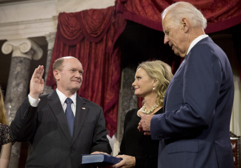 In this Jan. 6, 2015, file photo, Vice President Joe Biden administers the Senate oath to Sen. Chris Coons, D-Del., as Coons' wife, Annie Coons, watches during a ceremonial re-enactment swearing-in, in the Old Senate Chamber on Capitol Hill in Washington. When Coons speaks to the Democratic National Convention on Thursday, Aug. 20, before Biden’s speech accepting the party’s presidential nomination, his remarks will focus on faith — attesting in highly personal fashion to his longtime friend’s belief in God. (AP Photo/Jacquelyn Martin, File)