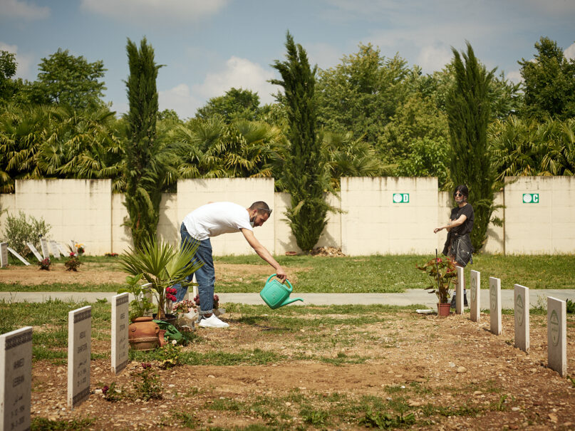 Jawad El Mehdi takes care of the burial site of his grandparents, who both died of complications related to COVID-19, at the Azzano San Paolo cemetery in Bergamo, Italy, in June 2020. Photo by Luca Quagliato