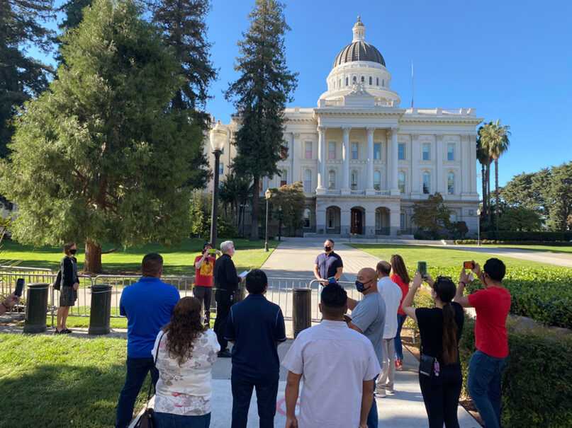 The Rev. John P. McGarry, center left, speaks outside the California State Capitol after leading a procession of laid-off hospitality workers from Sacramento's Cathedral of Blessed Sacrament to the Capitol. Photo courtesy of Unite Here Local 11