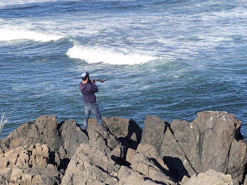 A man blows a shofar to celebrate the end of Rosh Hashanah on the Marginal Way, Sunday, Sept. 20, 2020 in Ogunquit, Maine. (AP Photo/Pat Eaton-Robb)