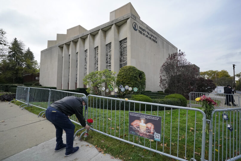 A man places flowers outside the Tree of Life synagogue in Pittsburgh on Tuesday, Oct. 27, 2020, the second anniversary of the shooting at the synagogue, that killed 11 worshippers. (AP Photo/Gene J. Puskar)