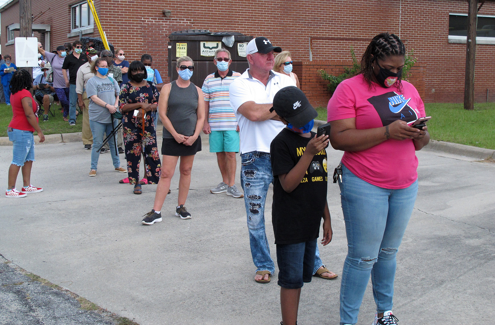 Voters wearing masks wait in line to vote early outside the Chatham County Board of Elections office in Savannah, Georgia, on Wednesday, Oct. 14, 2020. (AP Photo/Russ Bynum)