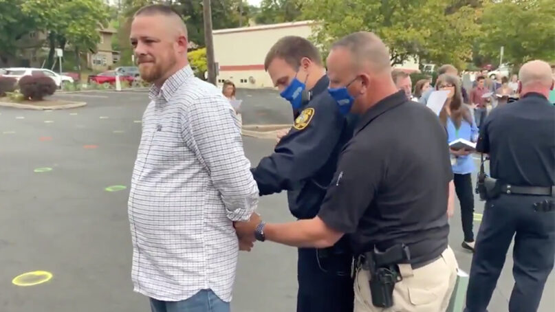 Gabriel Rench, left, is arrested during a “psalm sing” promoted by Christ Church in Moscow, Idaho. Video screengrab