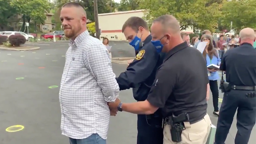 Gabriel Rench, left, is arrested during a “psalm sing” promoted by Christ Church in Moscow, Idaho. Video screen grab