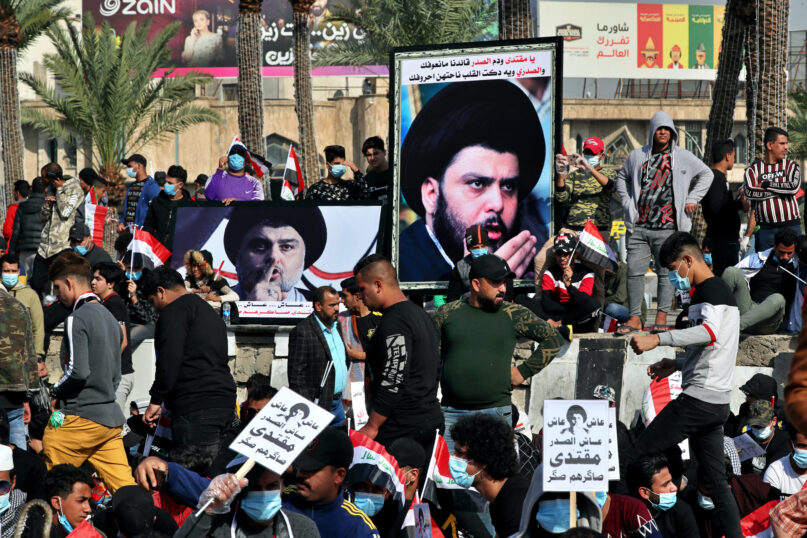 Followers of Shiite cleric Muqtada al-Sadr, in the posters, gather in Tahrir Square, Baghdad, Iraq, Friday, Nov. 27, 2020. Thousands took to the streets in Baghdad on Friday in a show of support for a radical Iraqi cleric ahead of elections slated for next year, stirring fears of a spike in coronavirus cases. (AP Photo/Khalid Mohammed)