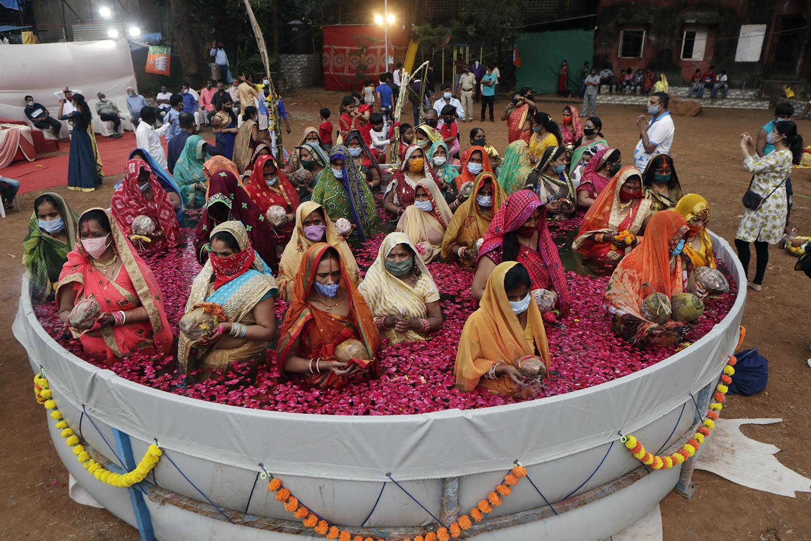 Indian women perform rituals standing inside an artificial pond for the Chhat Puja festival in Mumbai, India, Friday, Nov. 20, 2020. Health officials have warned about the potential for the coronavirus to spread during the upcoming religious festival season, which is marked by huge gatherings in temples and shopping districts. (AP Photo/Rajanish Kakade)