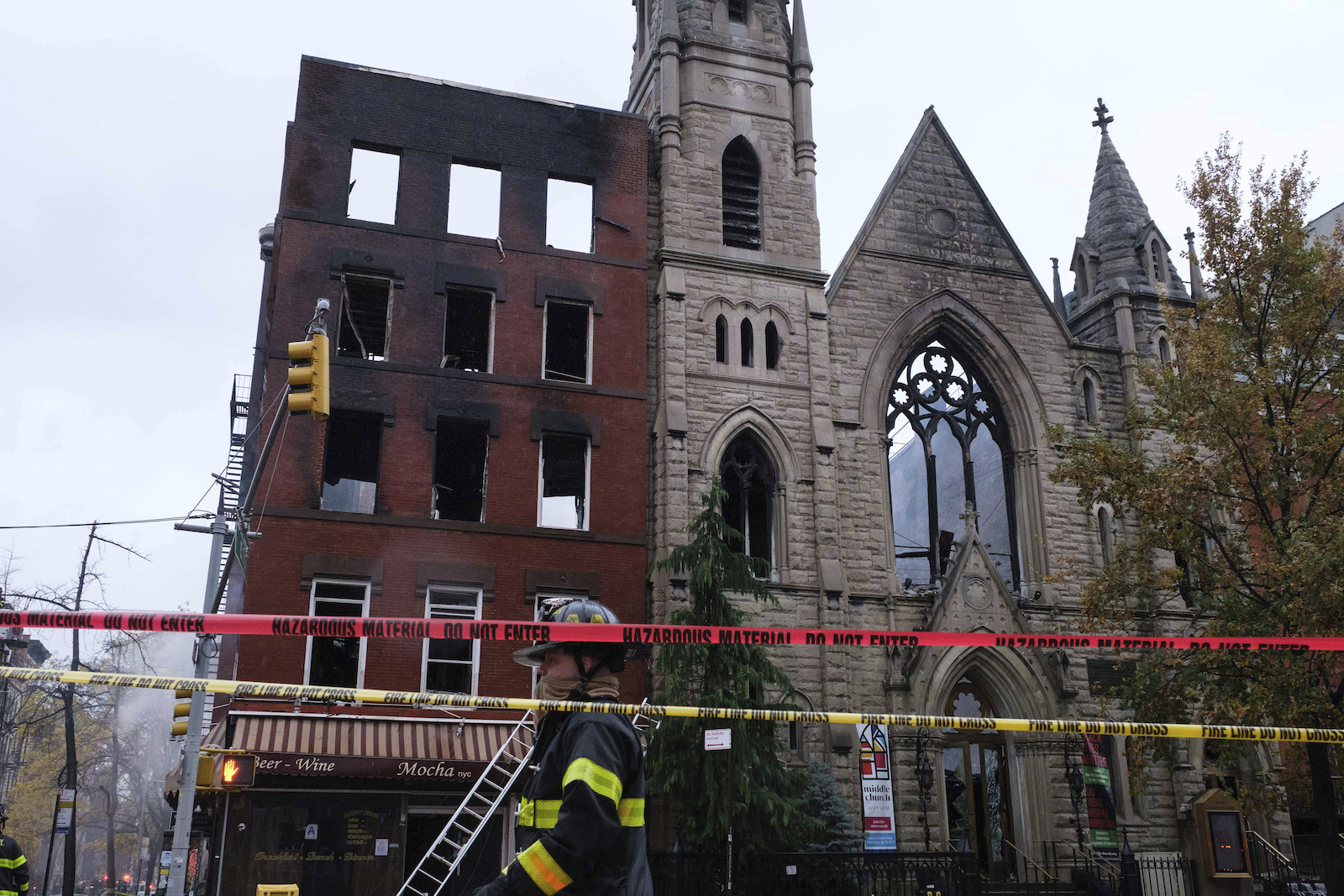 Firefighters work to extinguish a fire that erupted from the building next to Middle Collegiate Church on Dec. 5, 2020, in New York. The historic 19th-century church in lower Manhattan was gutted by a massive fire that sent flames shooting through the roof. The remaining facade will be demolished in 2023. (AP Photo/Yuki Iwamura)