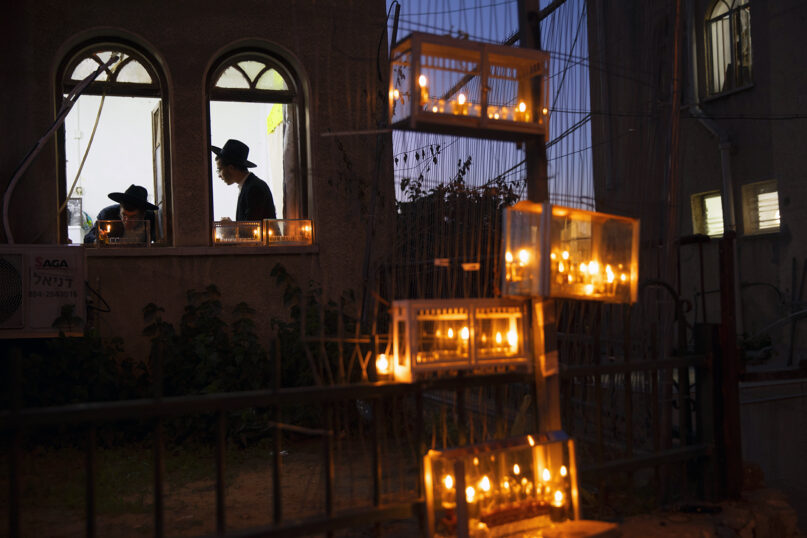 Ultra-Orthodox Jewish yeshiva students light candles on the first night of the Jewish holiday of Hanukkah in the ultra-Orthodox city of Bnei Brak near Tel Aviv, Israel, Thursday, Dec. 10, 2020. Hanukkah, also known as the Festival of Lights, is an eight-day commemoration of the Jewish uprising in the second century B.C. against the Greek-Syrian kingdom, which had tried to put statues of Greek gods in the Jewish Temple in Jerusalem. (AP Photo/Oded Balilty)
