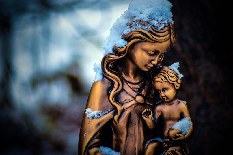 Snow covers a statue of the Mother Mary and baby Jesus. Photo by Anuja Tilj/Pixabay/Creative Commons