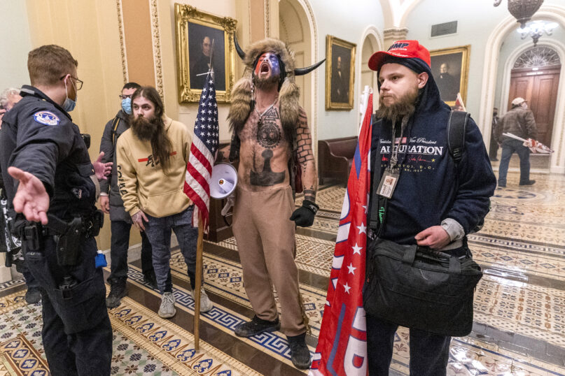 Jacob Chansley, center, better known as the “QAnon Shaman,” and other supporters of President Donald Trump are confronted by Capitol Police officers outside the Senate Chamber inside the Capitol, Jan. 6, 2021, in Washington. (AP Photo/Manuel Balce Ceneta)