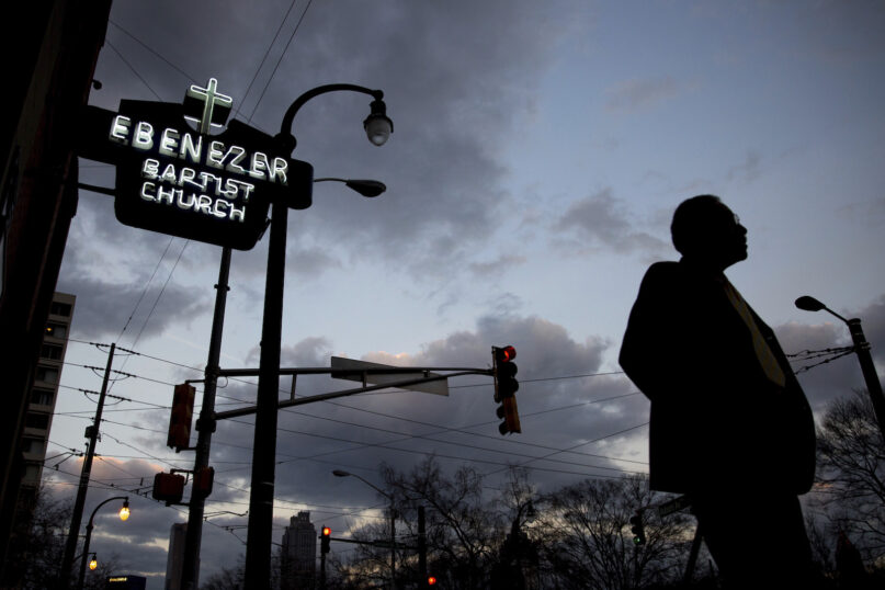 In this Jan. 16, 2017, file photo, a man walks past Ebenezer Baptist Church in Atlanta in the early morning. The historic congregation at the heart of Atlanta, where the Rev. Martin Luther King Jr. had preached, sits at the intersection of national politics and the fate of a handful of pressing national policy fights. (AP Photo/Branden Camp)