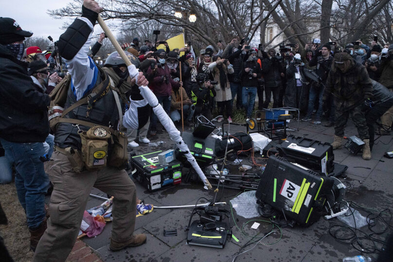 Demonstrators break TV equipment outside the the U.S. Capitol on Jan. 6, 2021, in Washington. (AP Photo/Jose Luis Magana)