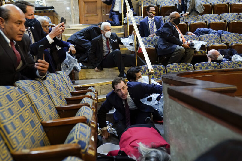People shelter in the House gallery as protesters try to break into the House chamber at the U.S. Capitol on Jan. 6, 2021, in Washington. (AP Photo/Andrew Harnik)