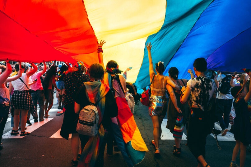 Marchers carry a large rainbow flag during the annual Pride parade in Portland, Maine. Photo by Mercedes Mehling/Unsplash/Creative Commons