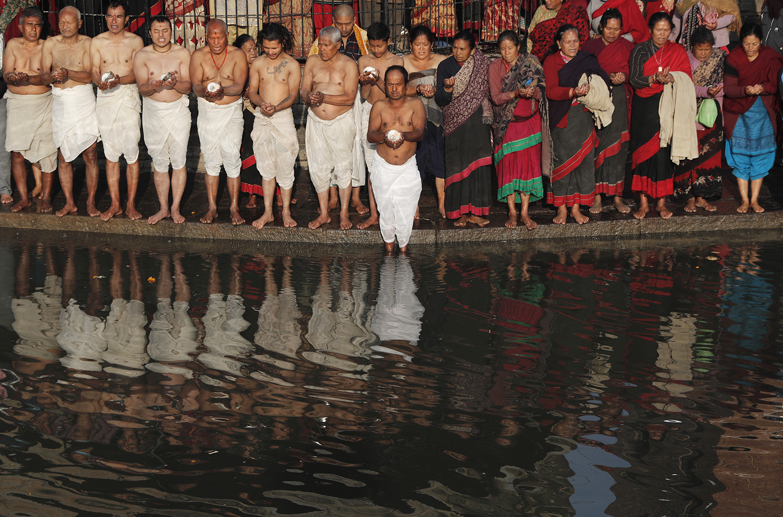 Nepalese Hindu devotees offer prayers during Madhav Narayan Festival along the banks of the Hanumante river in Bhaktapur, Nepal, Thursday, Jan. 28, 2021. During the festival, devotees recite holy scriptures dedicated to Hindu goddess Swasthani and Lord Shiva. Unmarried women pray to get a good husband while those married pray for the longevity of their husbands by observing a month-long fast. (AP Photo/Niranjan Shrestha)