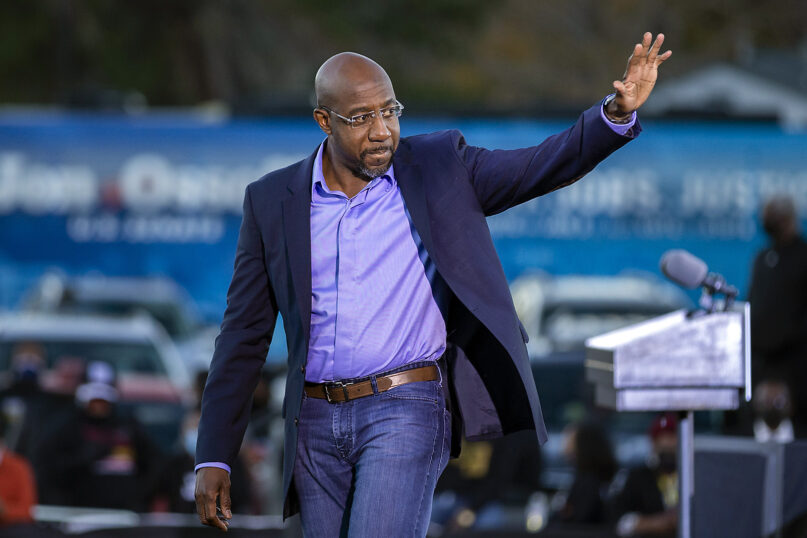 Democratic U.S. Senate candidate the Rev. Raphael Warnock waves to supporters during a drive-in rally Jan. 3, 2021, in Savannah, Georgia. Vice President-elect Kamala Harris made a campaign stop for Georgia candidates Warnock and Jon Ossoff before the runoff election Tuesday. (AP Photo/Stephen B. Morton)