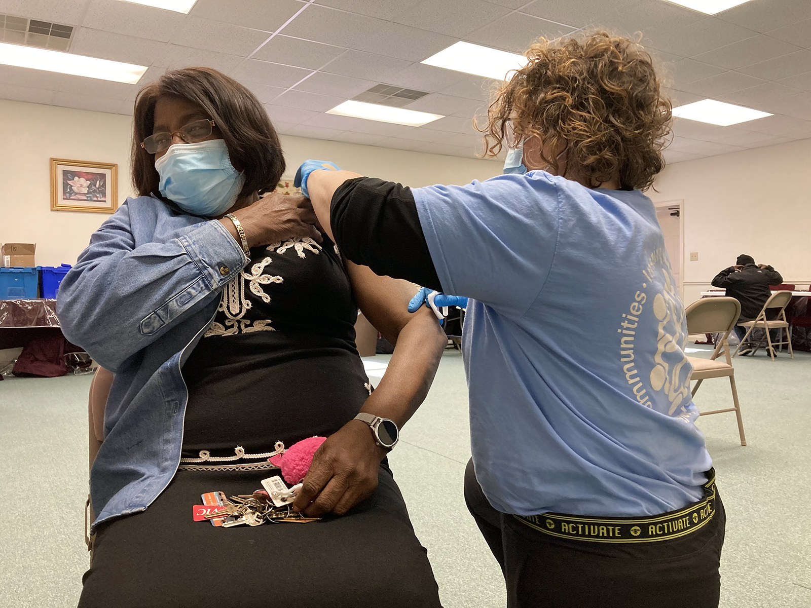 Nurse practitioner Monika Trogdon, right, gives a Moderna COVID-19 vaccination shot to Louella Neal, the pastor's wife, at a mobile vaccination clinic at Temple of Praise Church of Deliverance in Kenly, North Carolina, on on Wednesday, Feb. 17, 2021. RNS photo by Yonat Shimron