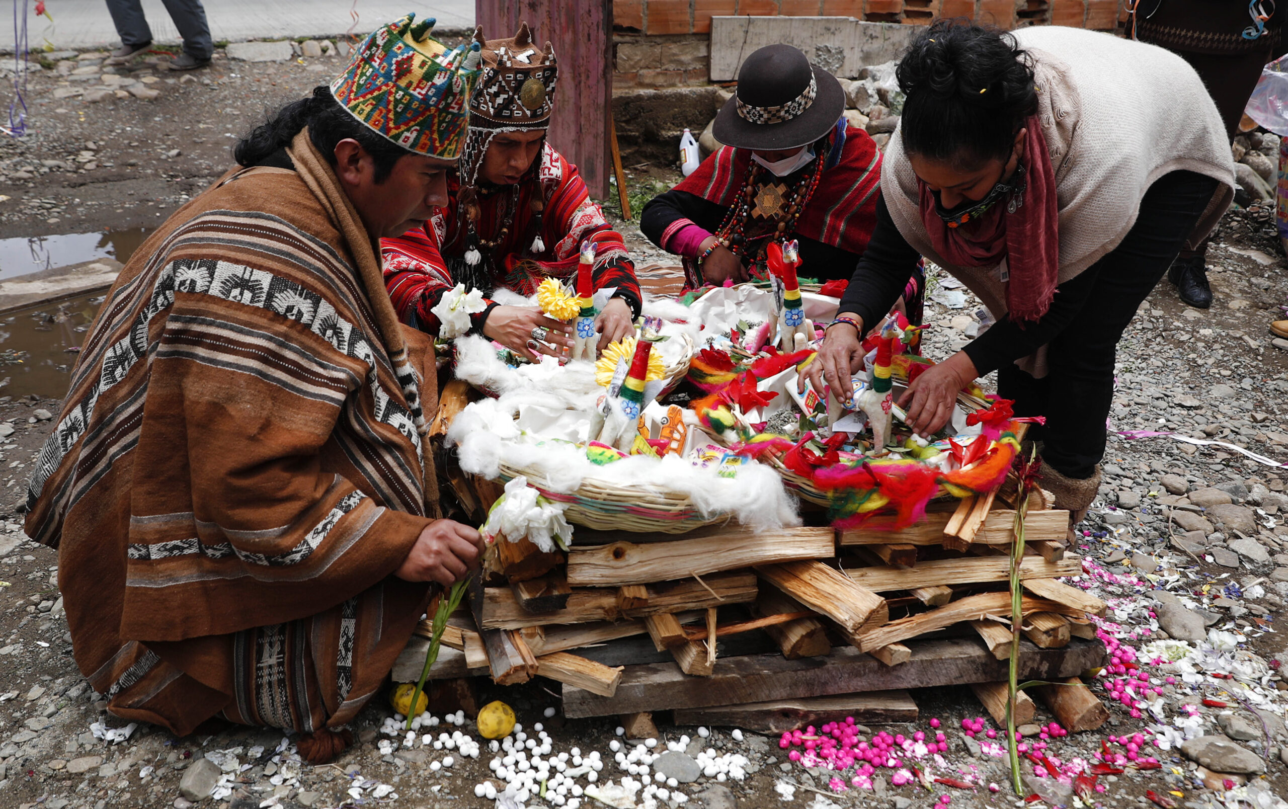 Spiritual guides prepare an offering to burn at a "Martes de Challa,” or Challa Tuesday celebration, in which devotees bury food, throw candies, burn incense, decorate their houses, businesses, cars, all in a show of gratitude to Pachamama or Mother Earth, in La Paz, Bolivia, Tuesday, Feb. 16, 2021. The Andean ritual coincides with the Christian holiday Shrove Tuesday, culminating with Carnival festivities to prepare for the Lenten season which begins Ash Wednesday, the following day. (AP Photo/Juan Karita)