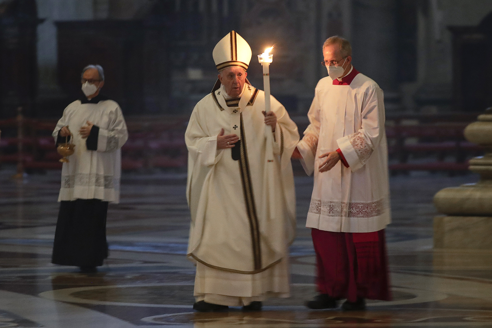 Pope Francis holds a candle as he arrives to celebrate a Mass with members of religious institutions on the occasion of the celebration of the World Day of Consecrated Life, in St. Peter's Basilica at the Vatican, on Feb. 2, 2021. (AP Photo/Andrew Medichini, pool)