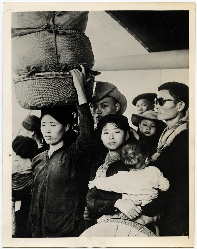 Here are some of the thousands of refugees of Northern Vietnam who left their homes after communists took over the area under the terms of the Geneva Pact, circa 1954. Although the French sent all available shipping to help them, under international law the would-be refugees had to make their own way out. They did this, despite high seas and the frailest of craft, pushing their way to freedom in an evacuation that took several days. These refugees are shown after they were taken aboard the French ship "Jules Verne." Despite the hazardous voyage, one refugee was able to hold on to her belongings which she carried in baskets on her head. RNS archive photo. Photo courtesy of the Presbyterian Historical Society
